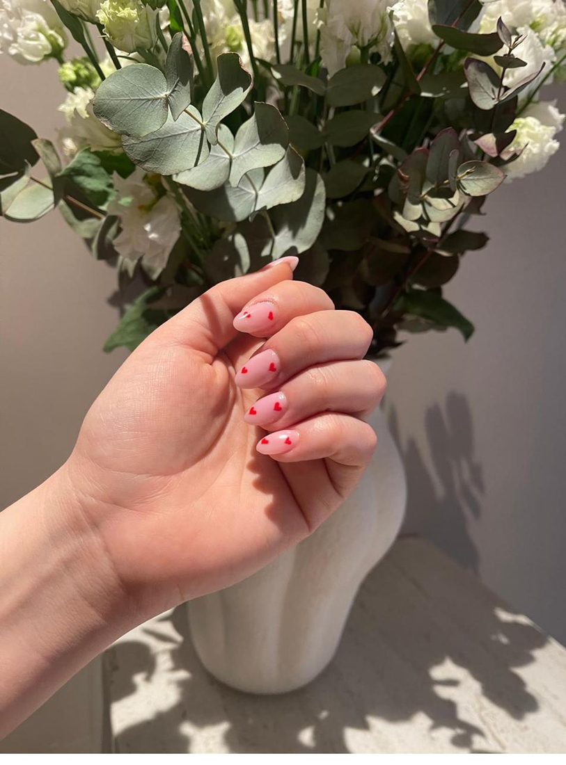 Rosa Nägel mit kleinen roten Herzen als Nail Art